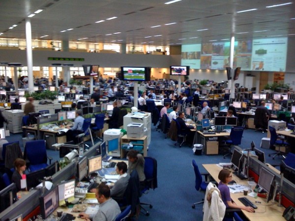 TMG main floor Section editors sit in conference (at centre, surrounded by TV screens)